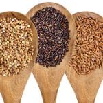 Three different types of seeds on wooden spoons.